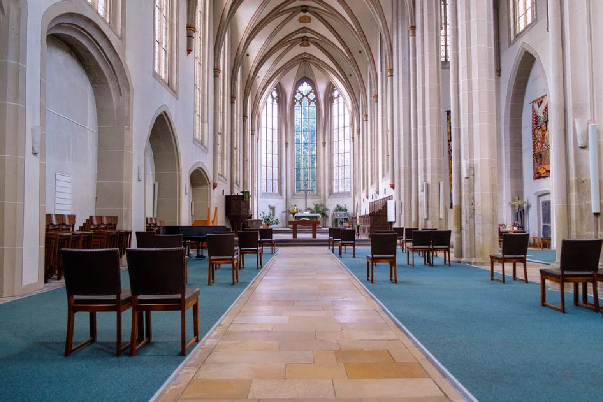 Gothic-style church interior with rows of chairs and an ornate altar.