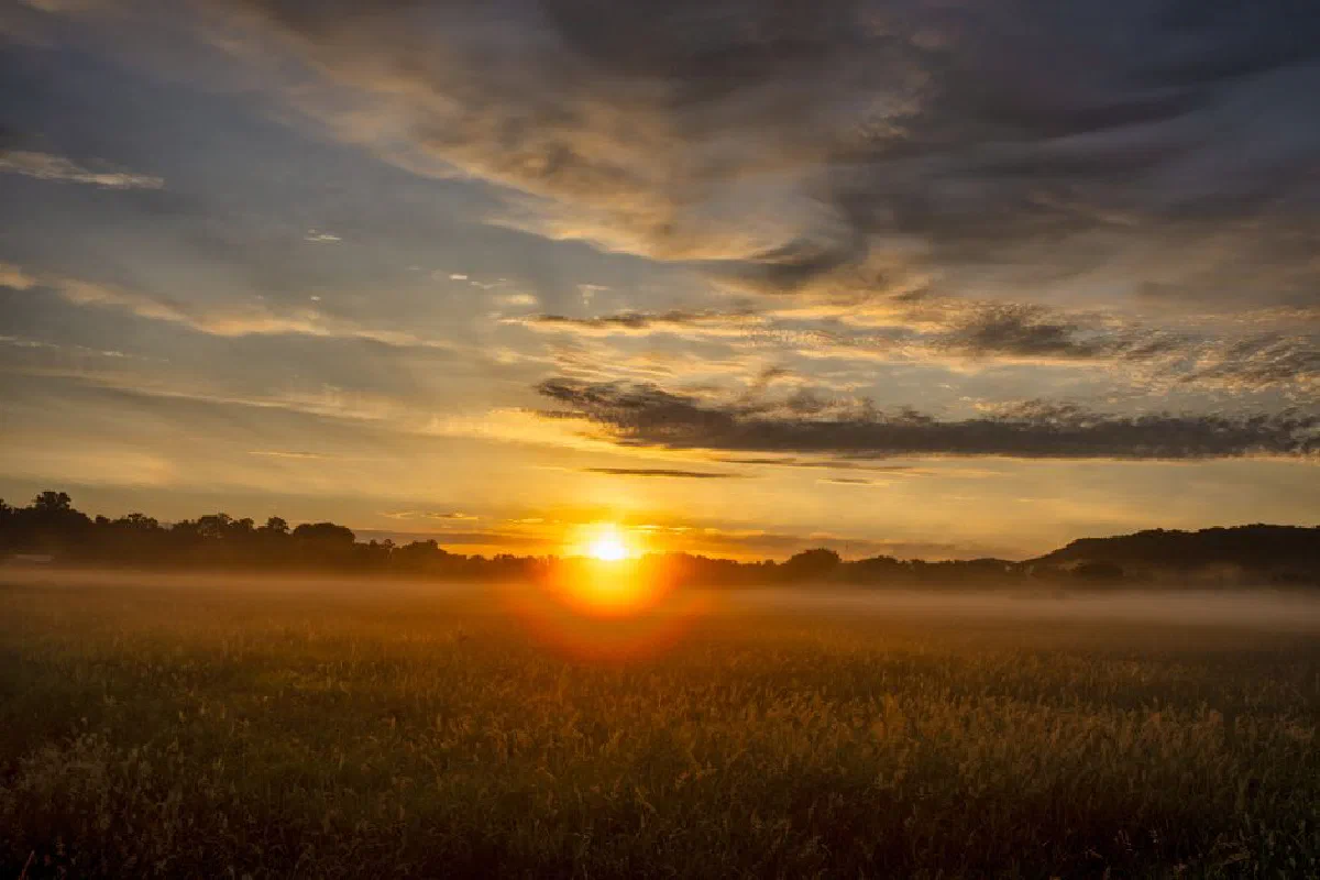 Dramatic sunrise with golden hues over a misty rural landscape in Modena, WI.