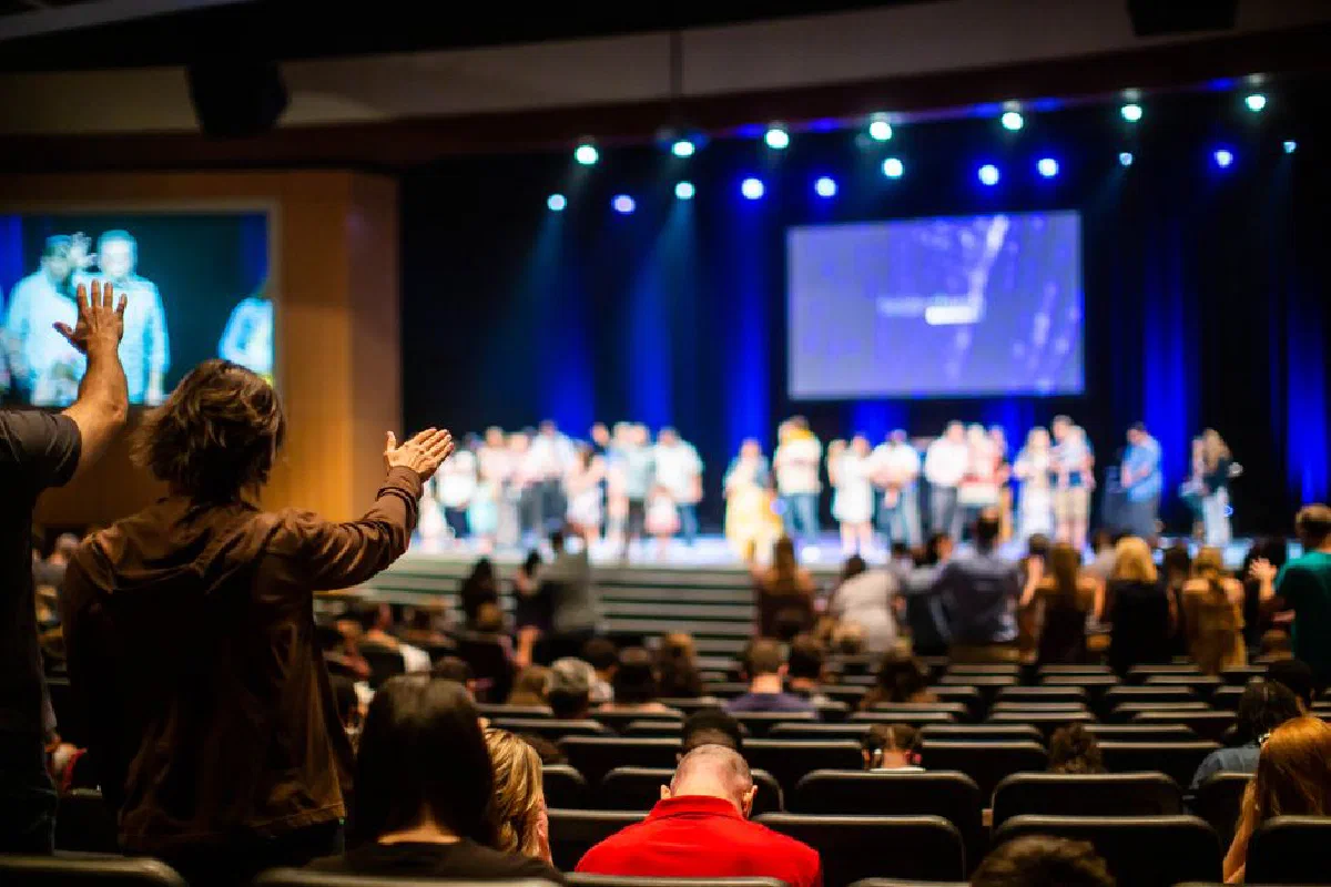 Lively indoor event capturing an audience engaging with a performance on stage in a well-lit auditorium.