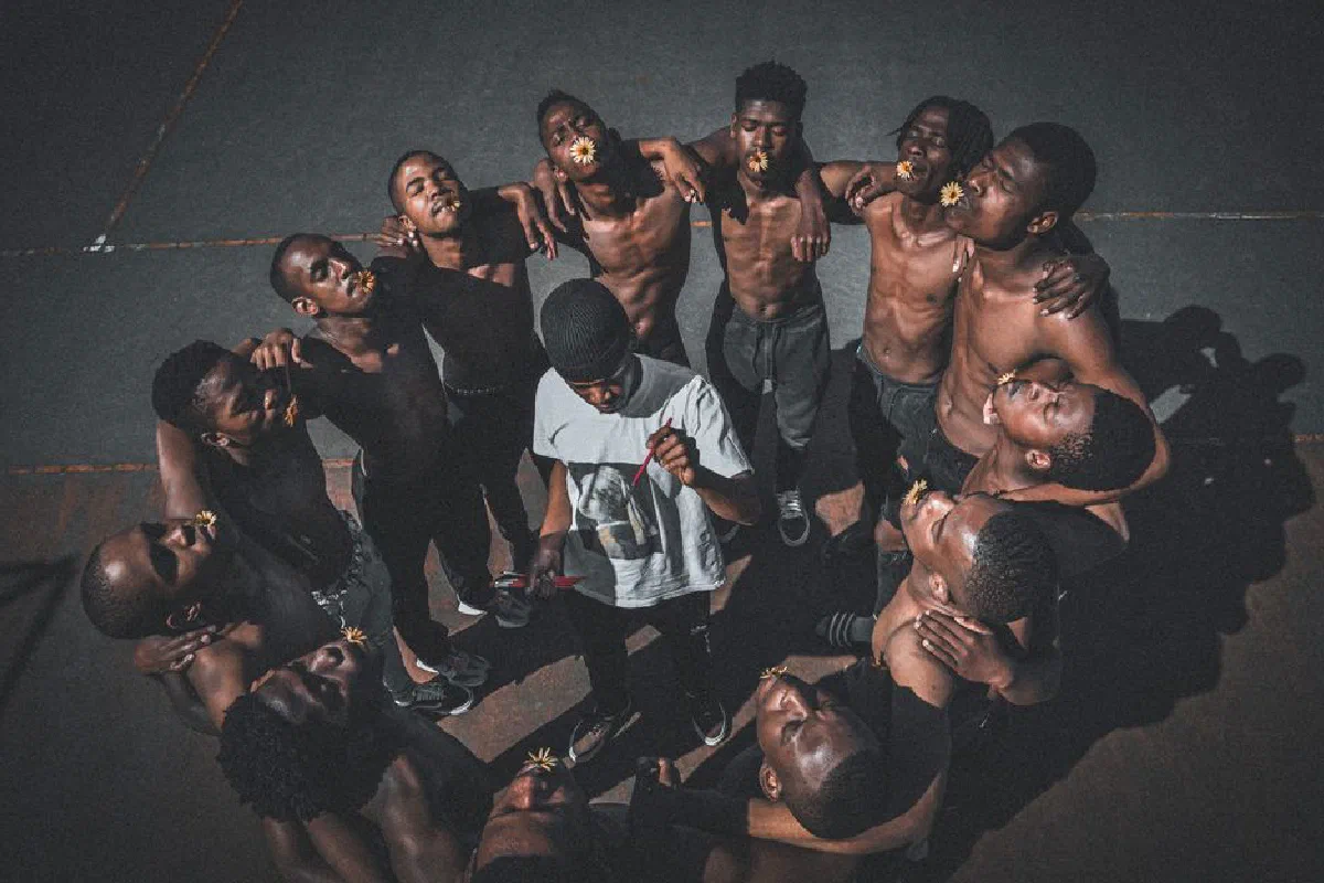 Aerial view of young men in circle, engaging in artistic expression with flowers.