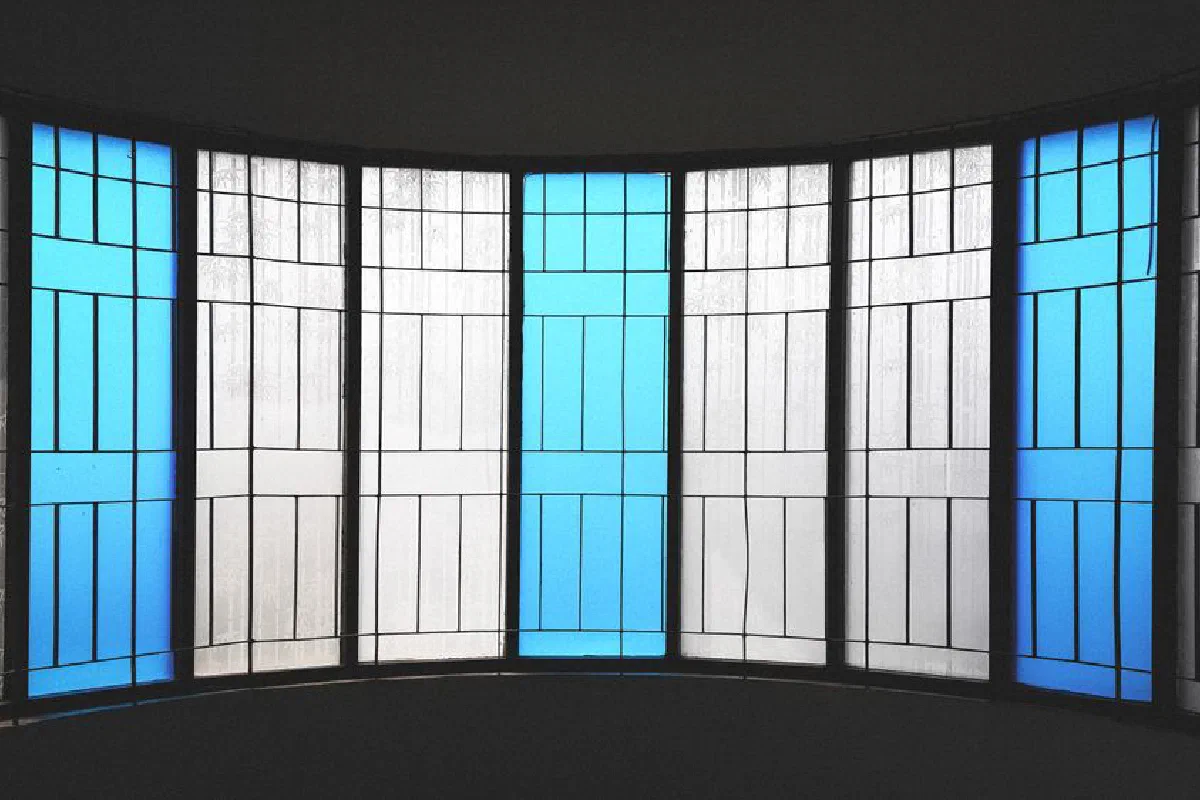 Elegant stained glass window with blue geometric patterns, creating a serene ambiance.