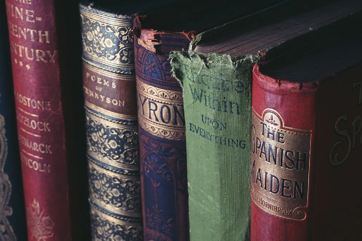 Close-up of vintage hardcover books showcasing ornate book jackets and titles.