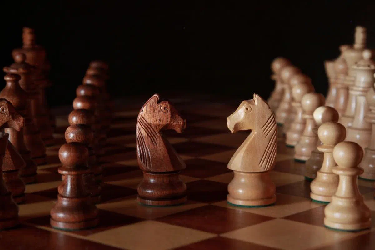 A close-up of wooden chess pieces on a chessboard, showcasing strategic depth and craftsmanship.
