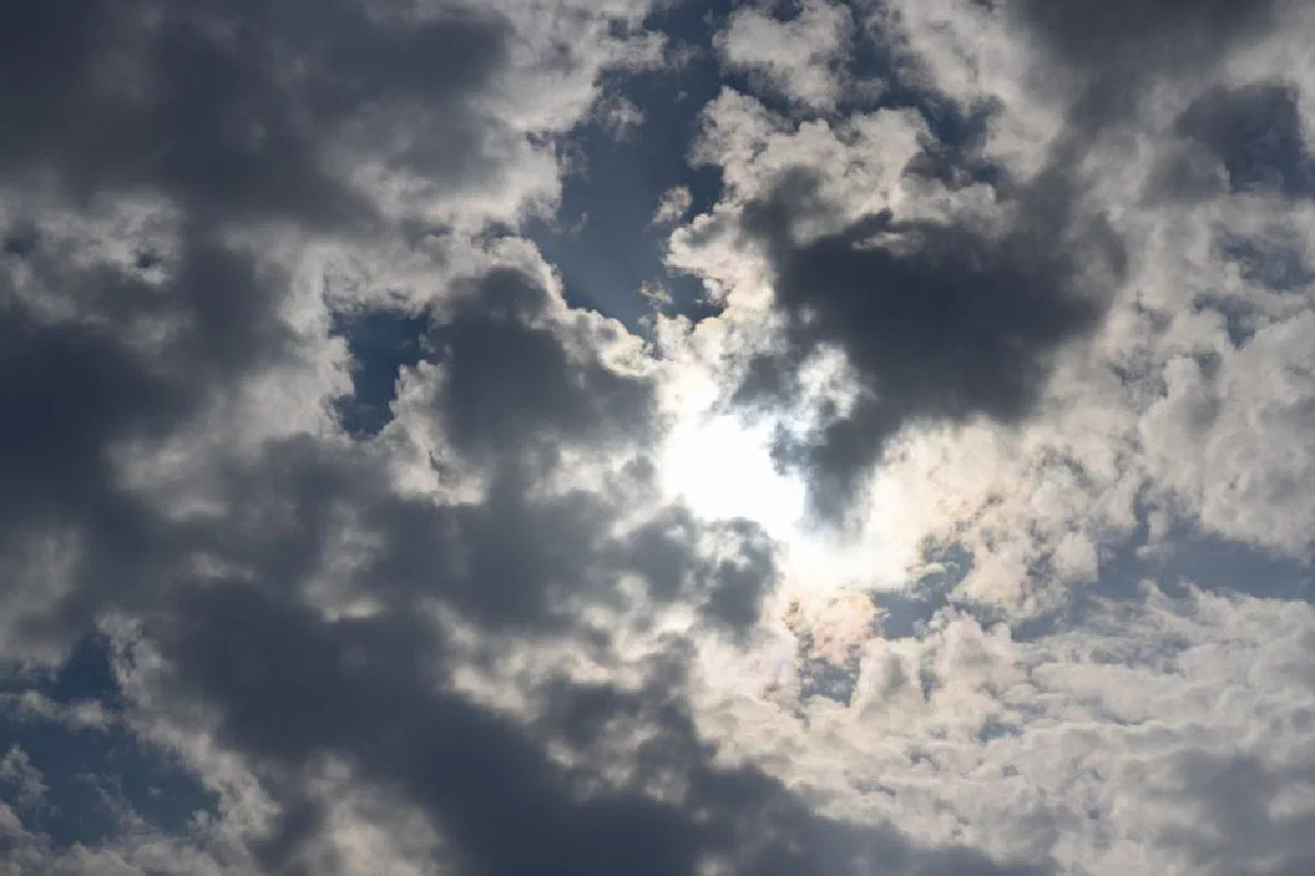 Majestic clouds fill the sky with sunlight breaking through, casting dramatic shadows.