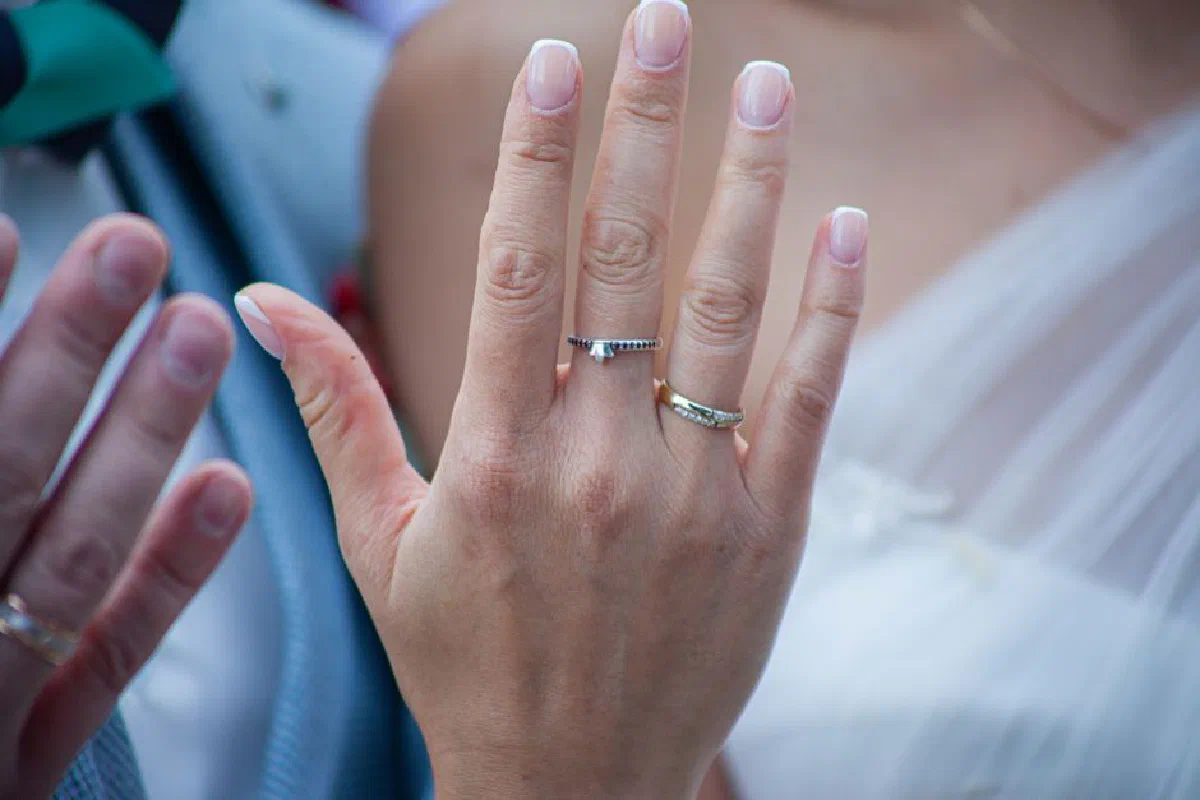 A close-up view of wedding rings on a bride's hand, symbolizing commitment and love.