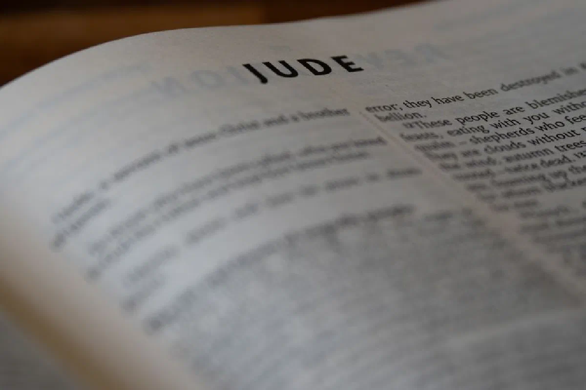 A close-up shot of a Bible opened to the Book of Jude, highlighting the text vividly.