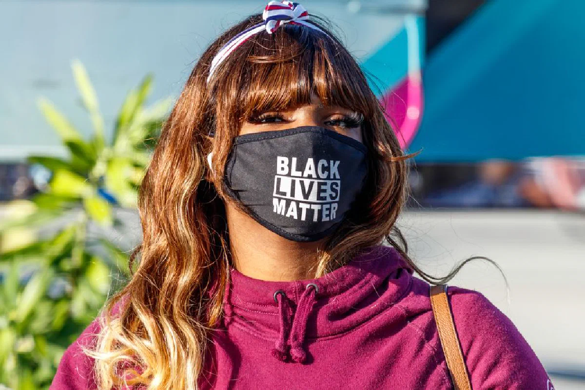 A woman in Palm Beach wearing a Black Lives Matter mask, symbolizing activism and equality.