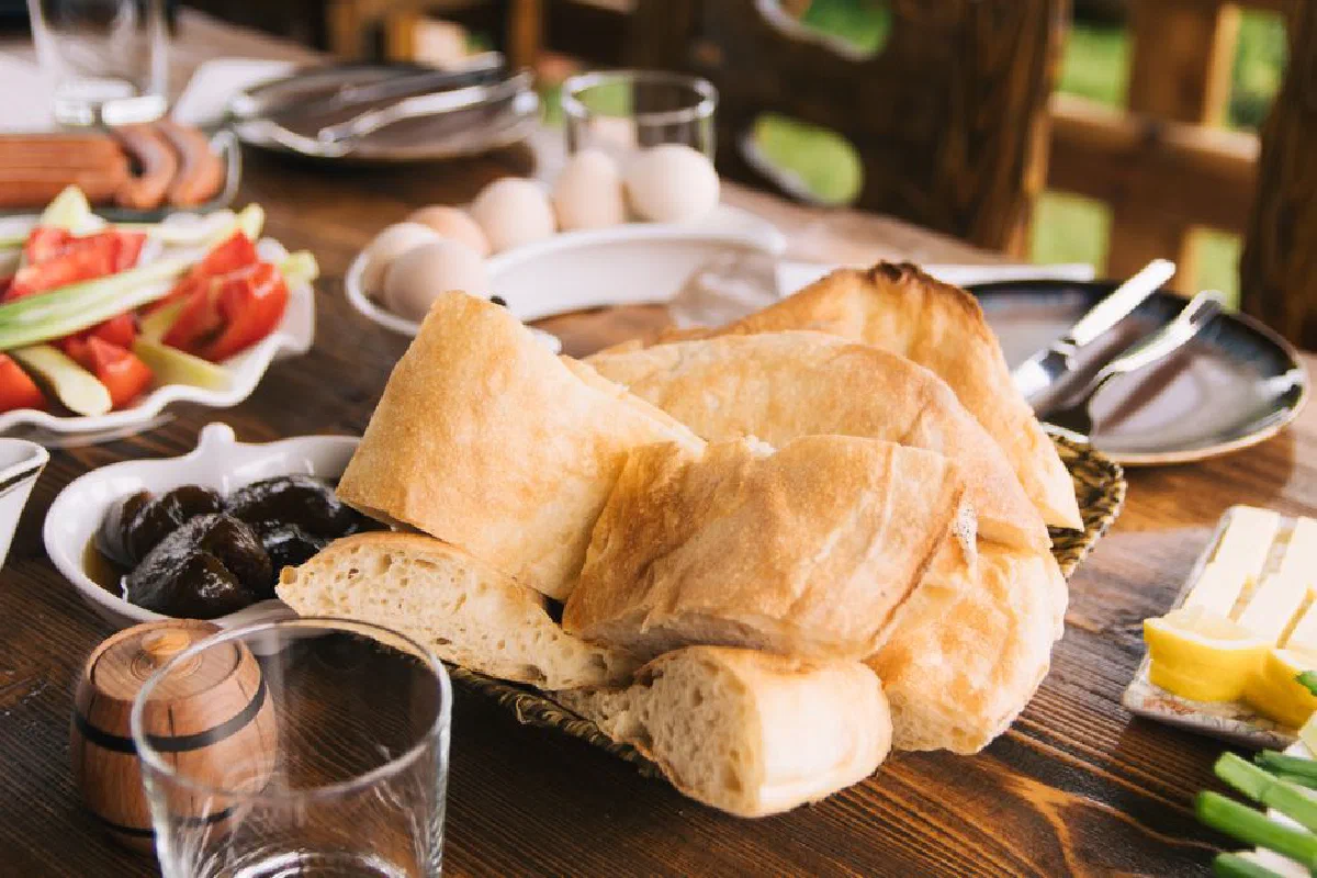 A delicious assortment of rustic breads and fresh ingredients on a wooden table, perfect for a breakfast feast.