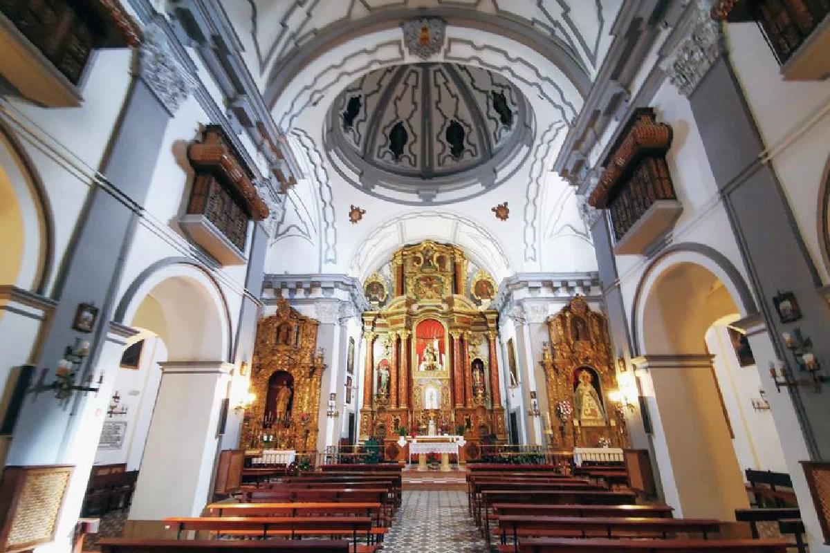 Beautifully ornate interior of a Catholic church with altar and benches.