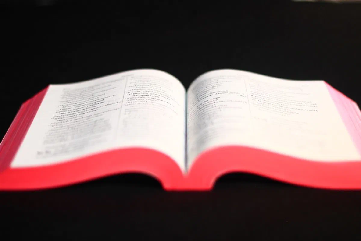 Khmer Bible open on a black surface, highlighting religious text.