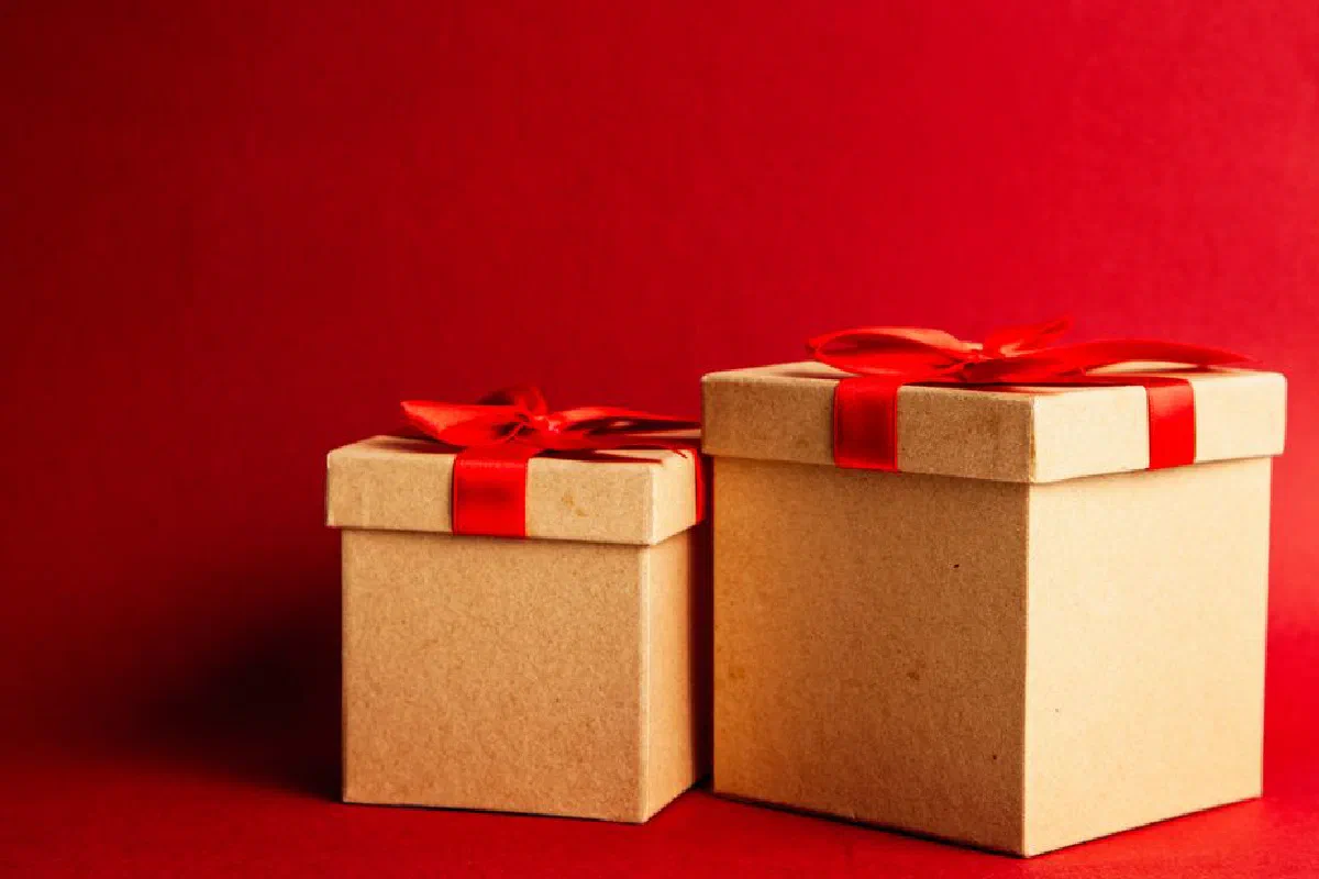 Two gift boxes with red ribbons on a vibrant red background.