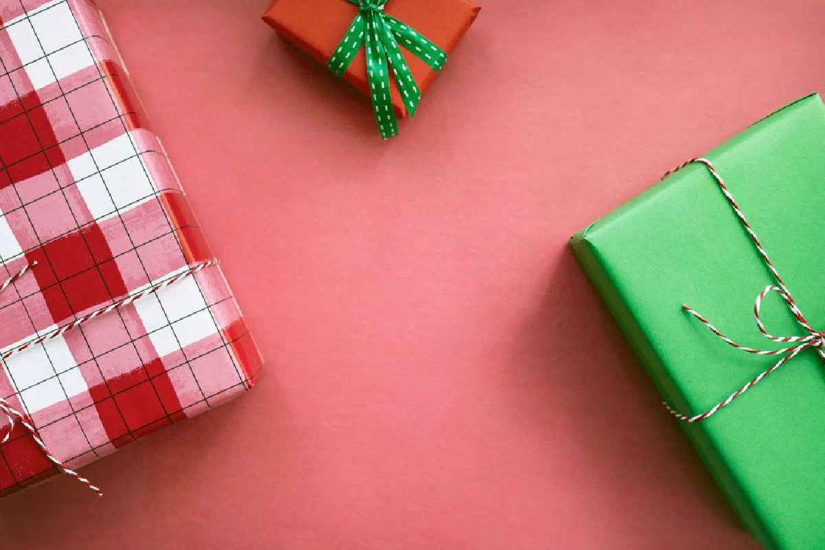 Colorful gift boxes with festive wrapping on a red background, perfect for holiday themes.