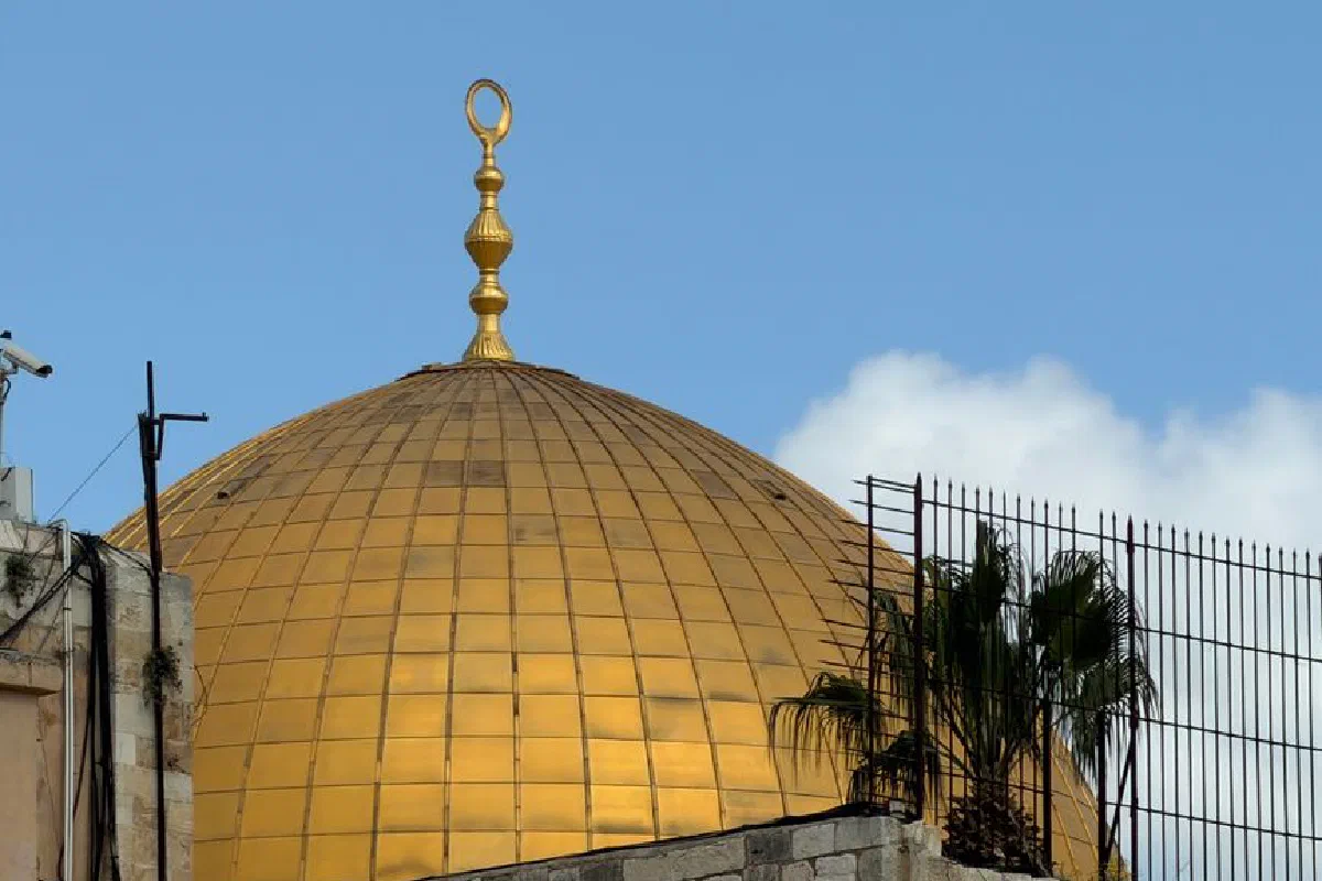 Close-up view of the Dome of the Rock's golden dome against a blue sky in Jerusalem.