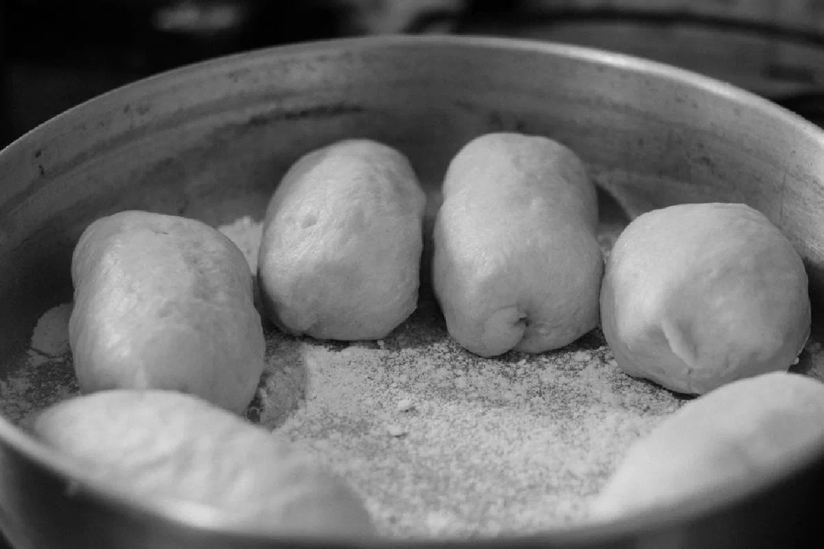 Close-up of homemade dough balls in a metal pan, ready for baking.
