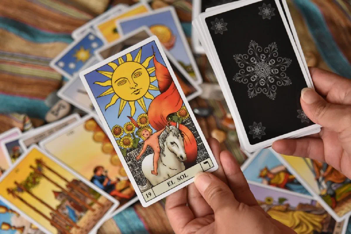 A detailed tarot card reading session featuring the 'El Sol' card with vibrant colors and mystical symbolism.