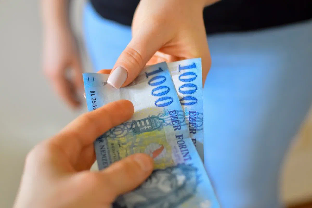 An exchange of 1000 Hungarian Forint banknotes between two hands.
