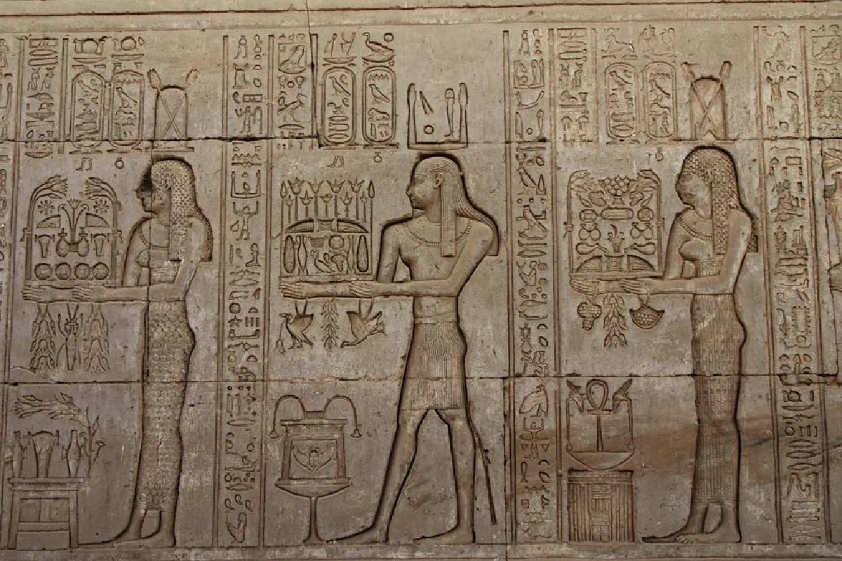 Detailed stone carvings of Egyptian hieroglyphs on the walls of Dendera Temple, Egypt.