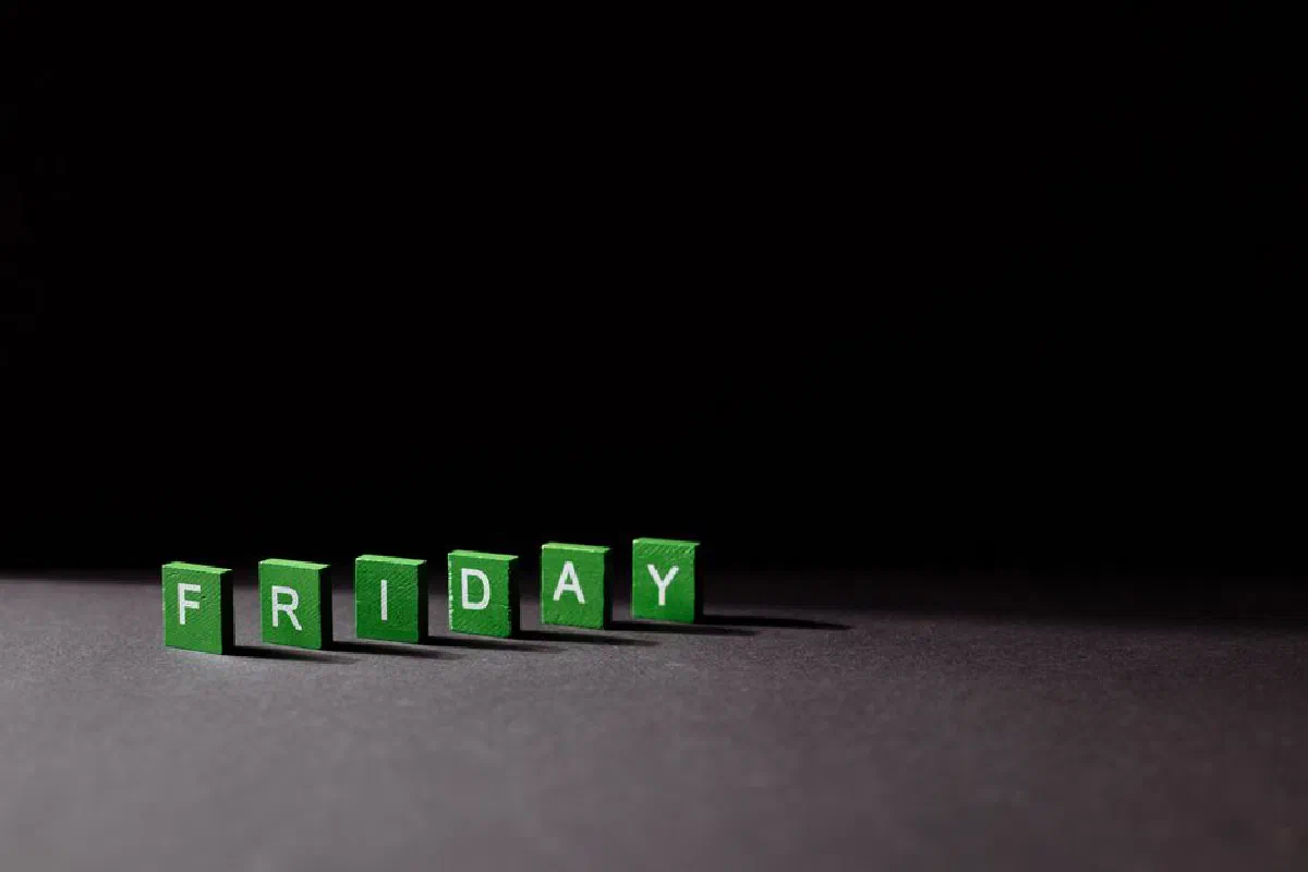 Green letter tiles spelling 'Friday' on a dark background, with dramatic lighting casting shadows.