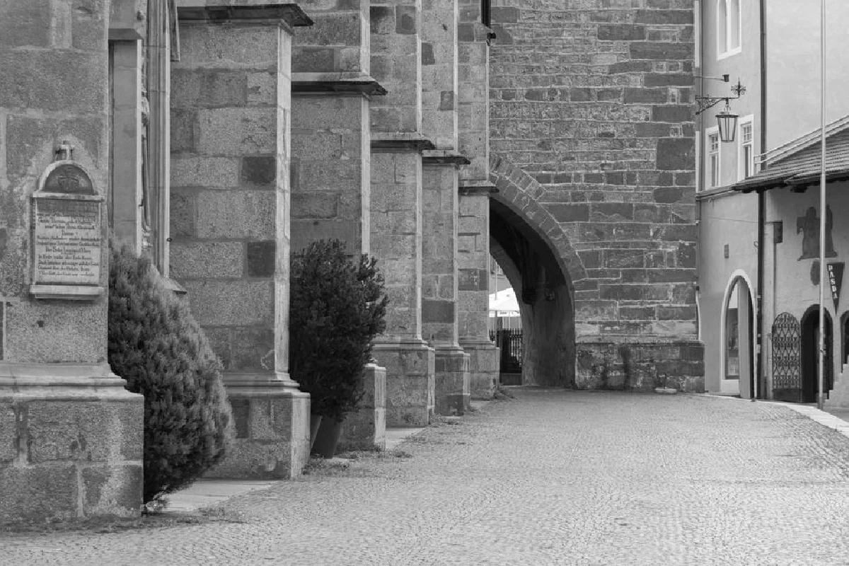 Black and white capture of historic stone passage in Meran, Italy.