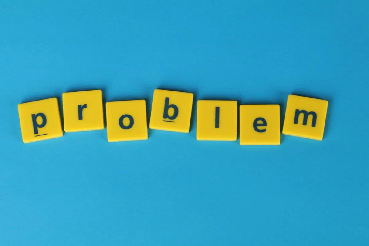 Yellow Scrabble tiles spelling 'problem' on a blue background, symbolizing challenge.