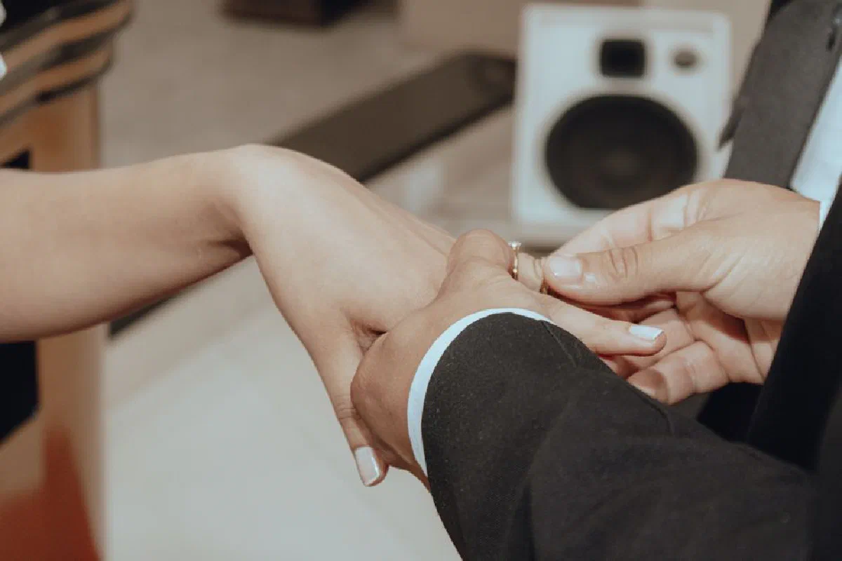 Intimate moment of a couple exchanging rings, symbolizing commitment and love.