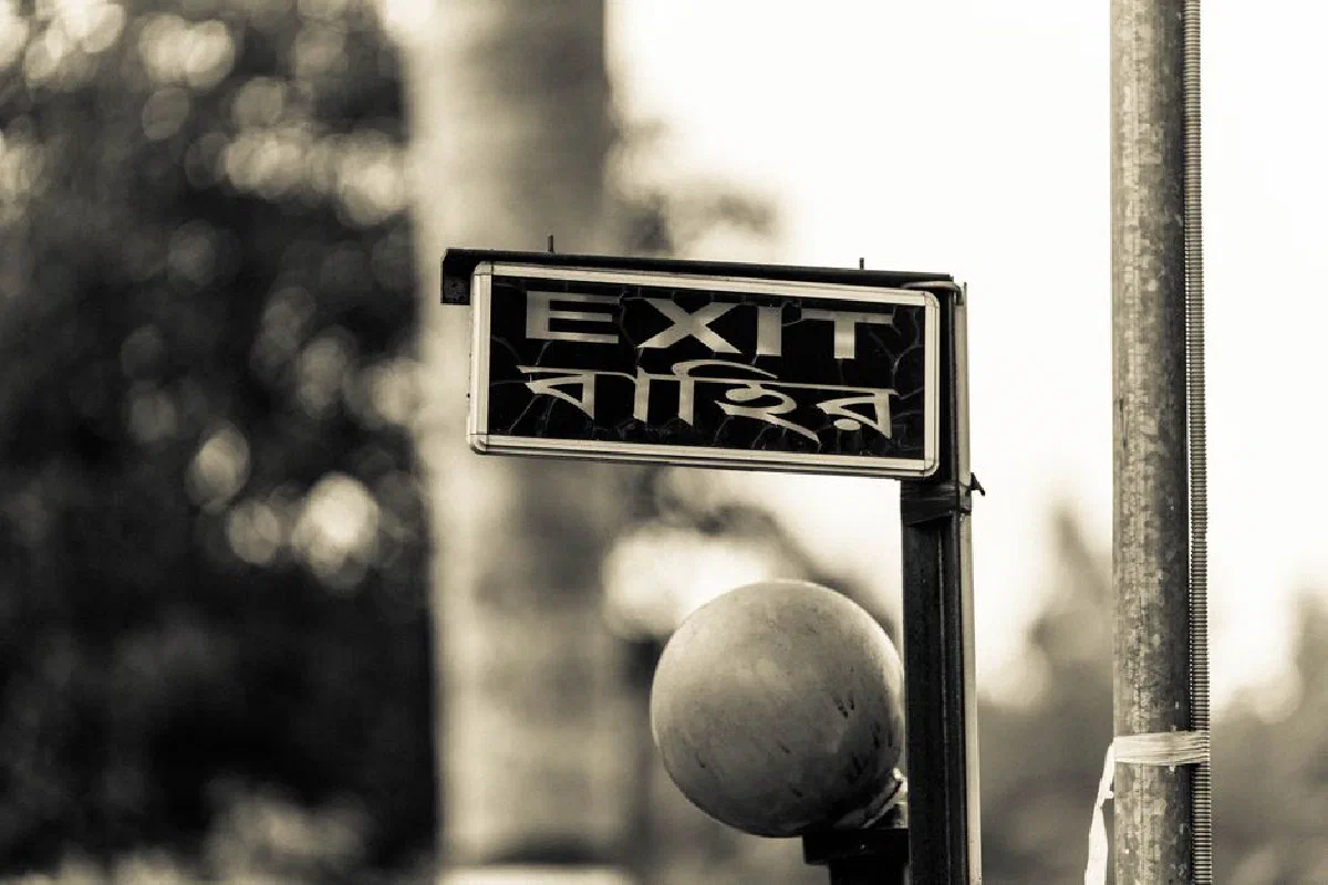Black and white photo of a bilingual exit sign in Faridpur, Bangladesh.