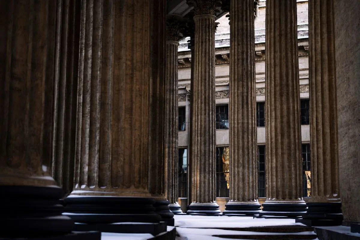 Snow-covered classical columns in grand architecture, evoking a timeless winter aesthetic.