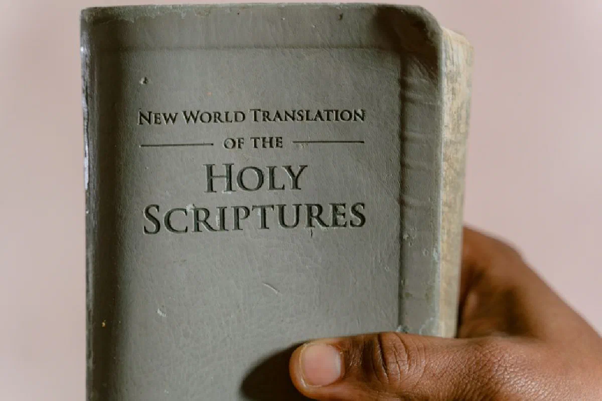 Close-up of a hand holding the New World Translation of the Holy Scriptures.