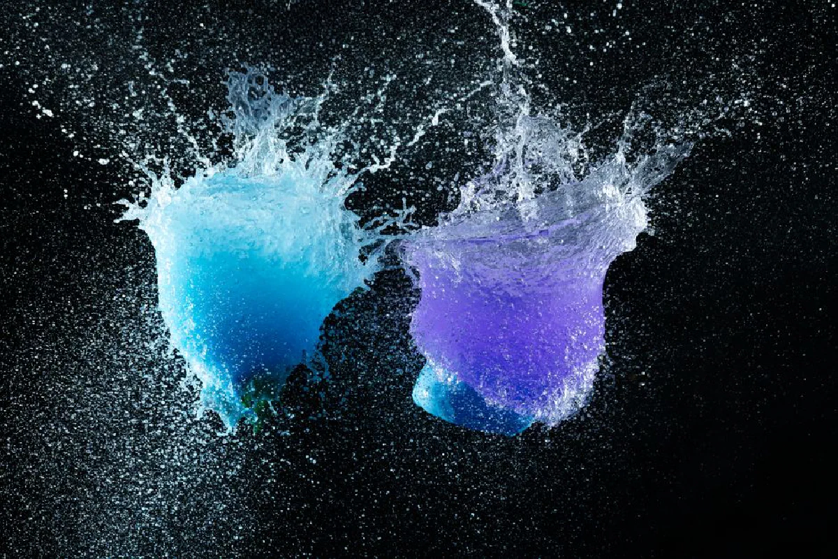High-speed capture of vibrant blue and purple water splashes on a black background.
