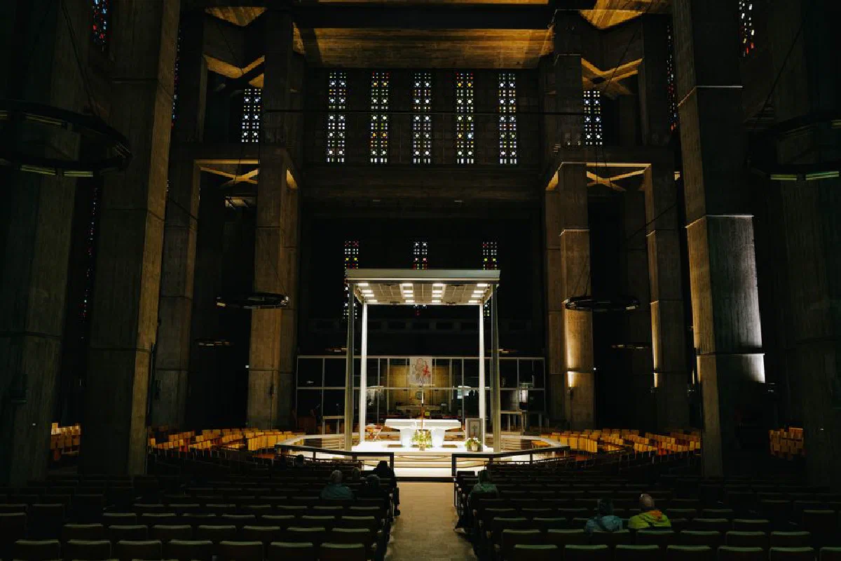 A serene view of a modern cathedral interior at night, showcasing unique architectural design and lighting.