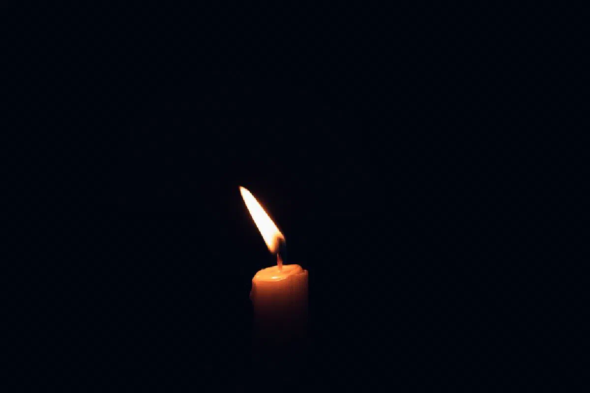 A solitary candle flame creating ambience in the dark with ample copy space.