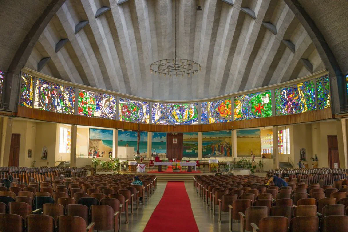 Beautiful interior of an empty church with vibrant stained glass windows and wooden chairs.