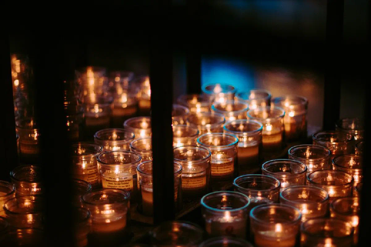 A serene arrangement of lit candles illuminating a dark room, creating a tranquil ambiance.
