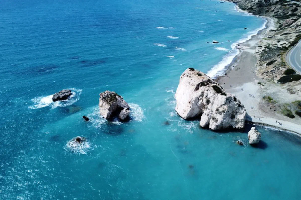 Stunning aerial view of Aphrodite's Rock, a famous coastal formation in Cyprus, in vibrant blue waters.