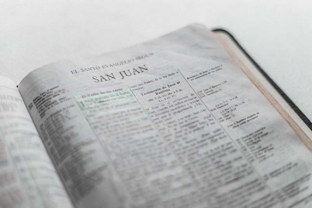 An open Spanish Bible displaying the Gospel of John's text in a soft, light setting.