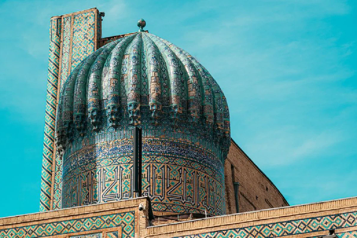 Capture of a stunning architectural dome with vivid mosaic patterns against a bright sky in Uzbekistan.