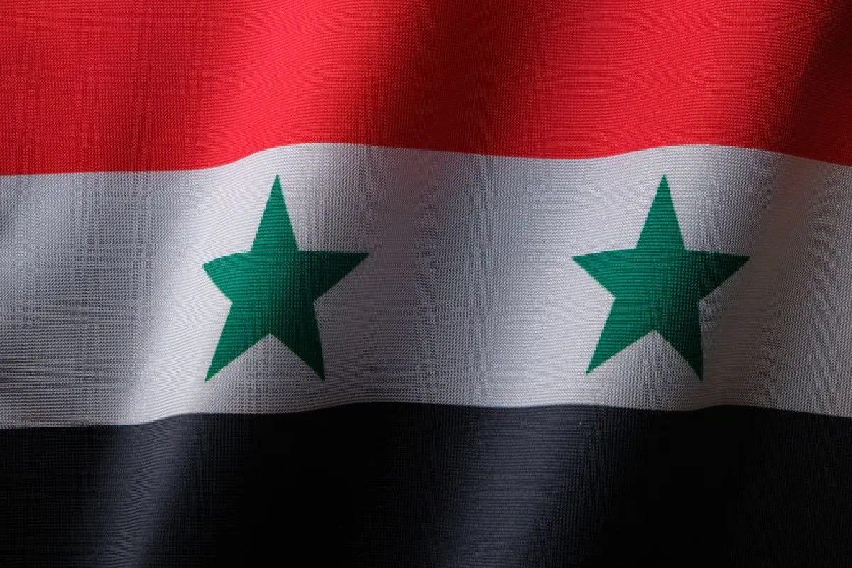 High-quality close-up of the Syrian national flag with textile texture.