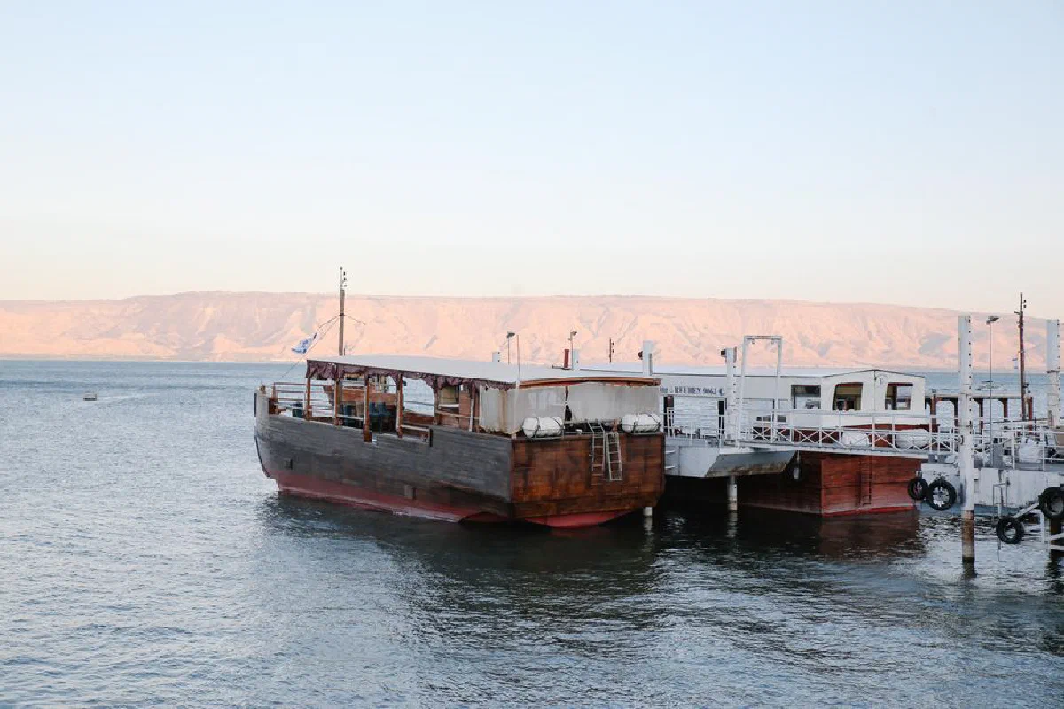 Traditional wooden boats docked at a serene marina in Israel's Sea of Galilee.