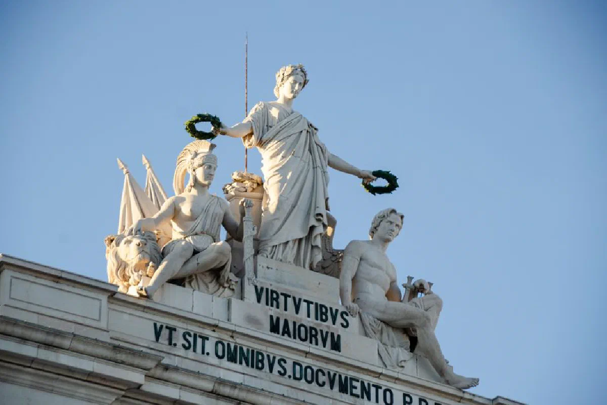 Statues atop the Arco da Rua Augusta in Lisbon, illuminated by daylight.