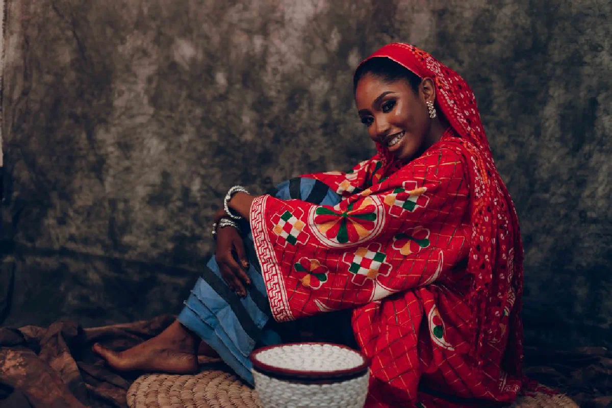 Beautiful African woman smiling in vibrant traditional attire, showcasing cultural heritage.