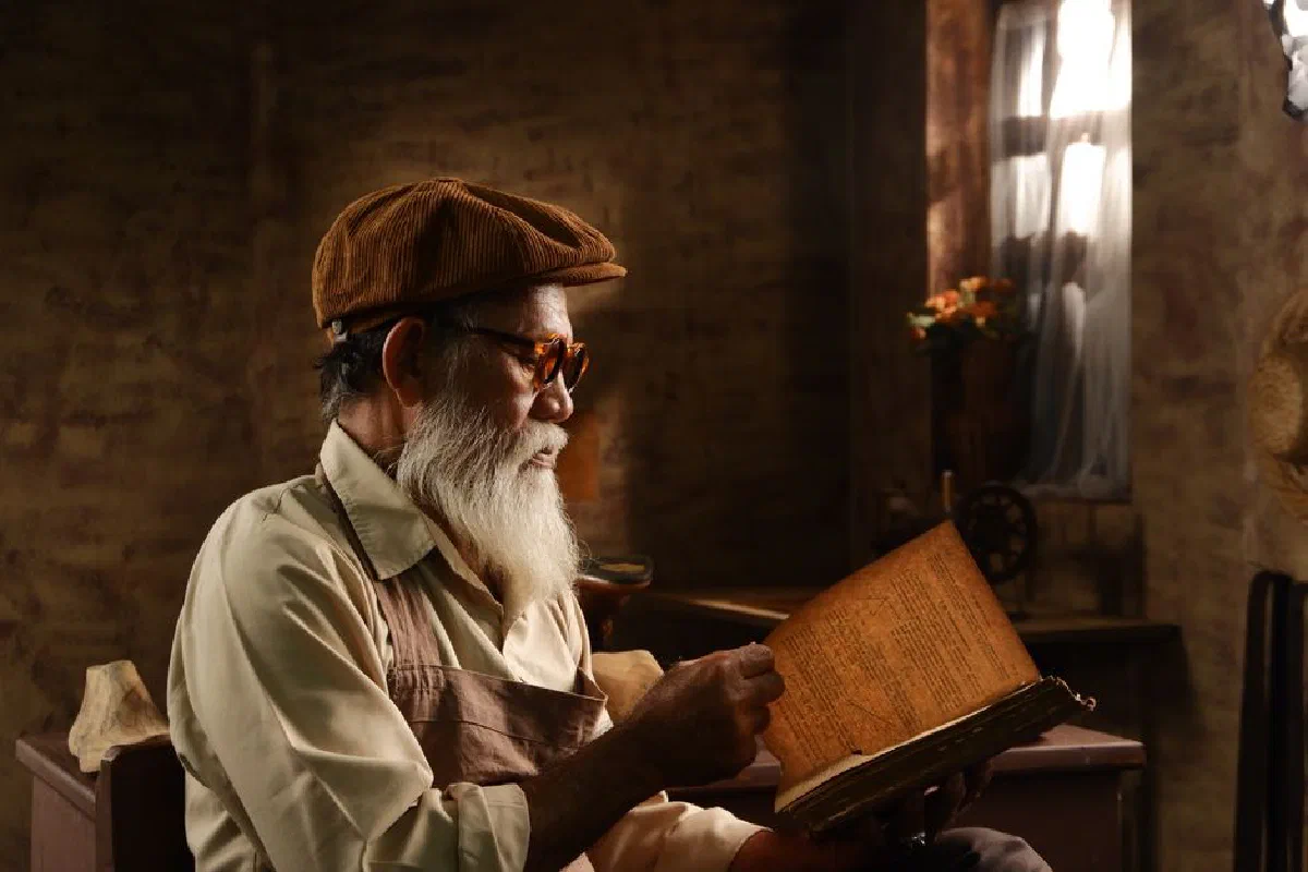 Senior man immersed in reading a vintage book in a nostalgic, cozy setting.