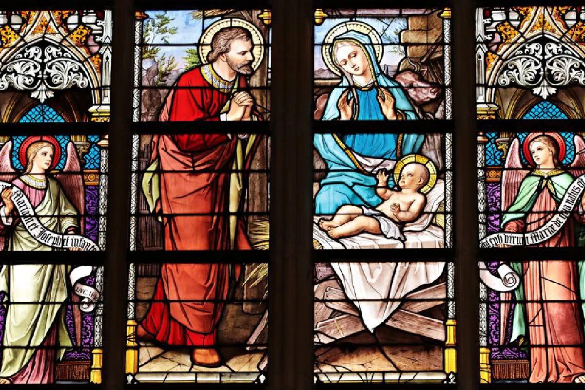 Vibrant stained glass window illustrating a biblical nativity scene with vivid colors in a church setting.