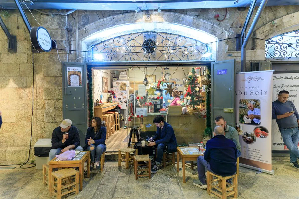 People enjoying a cozy evening at La Patisserie Abu Seir café in Jerusalem.