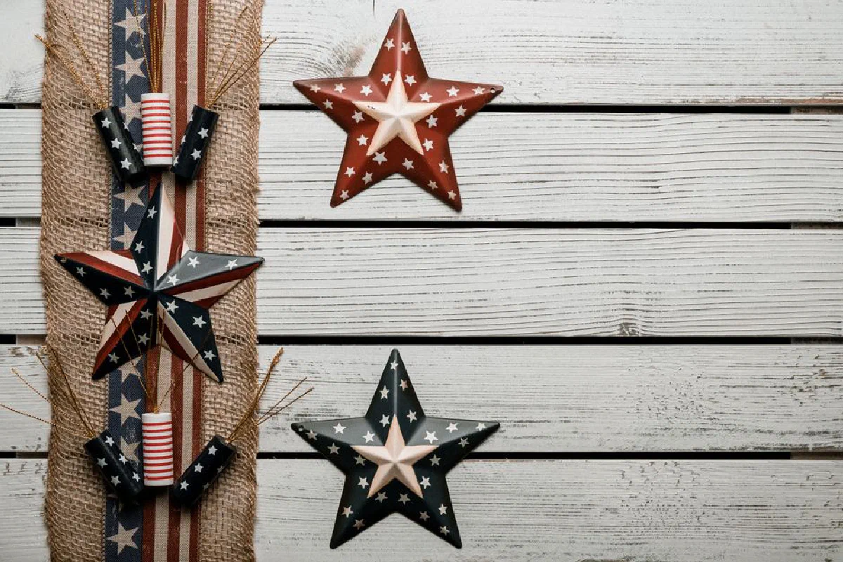 Top view composition of decorative ribbon in American flag style placed on white plank surface near national symbolic stars