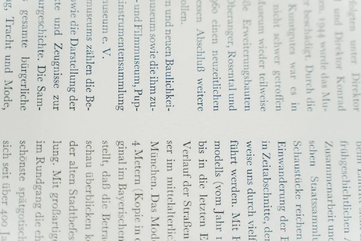Detailed close-up of German text printed on white paper, focusing on typography.