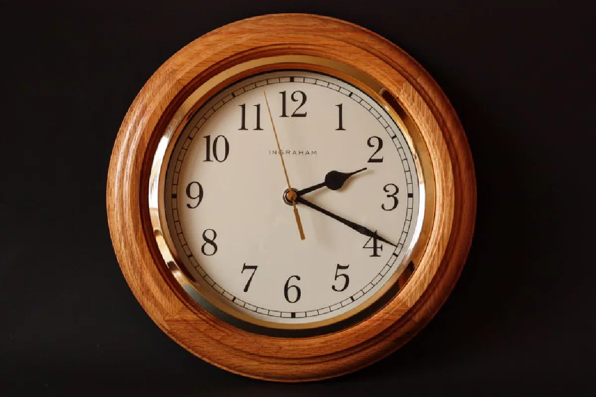 A classic wooden wall clock featuring a traditional dial and elegant design, perfect for timeless decor.