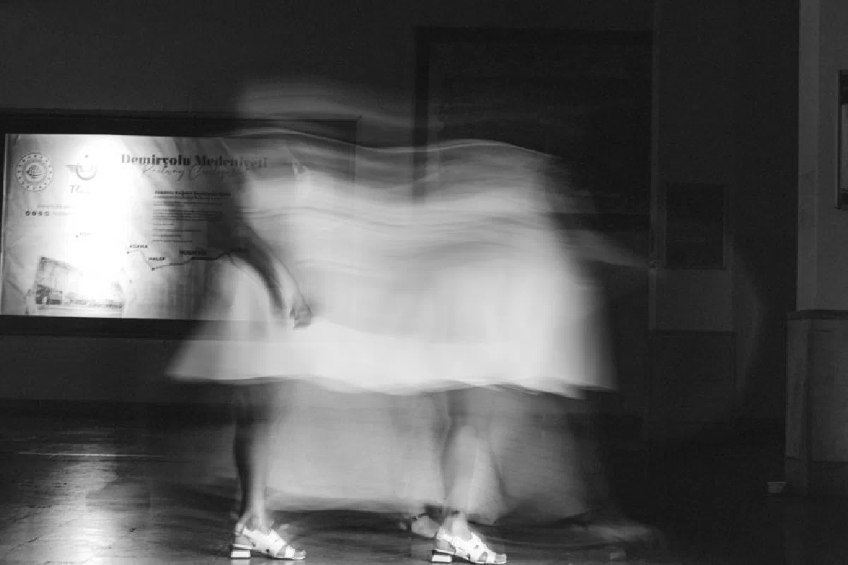 Artistic black and white photo capturing blurred motion of a person indoors.