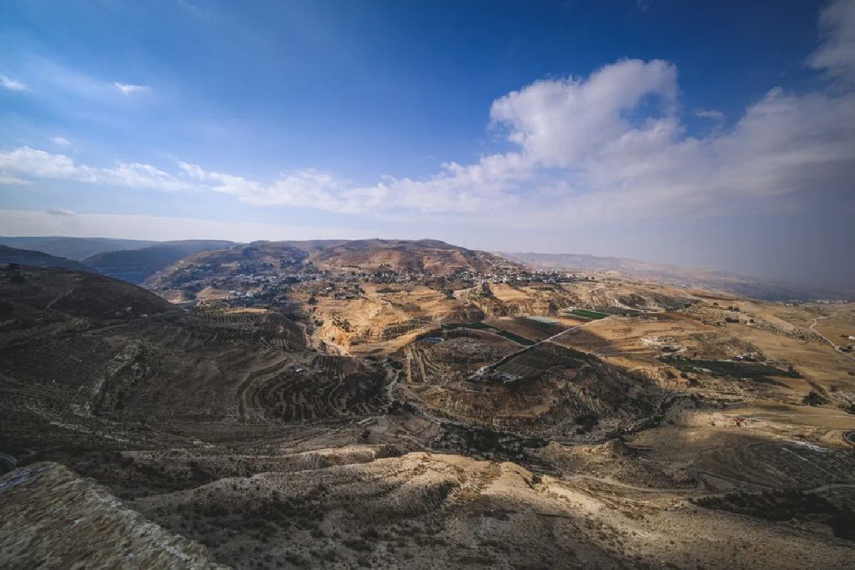 Explore a vast arid desert landscape with rugged mountains under a striking blue sky.