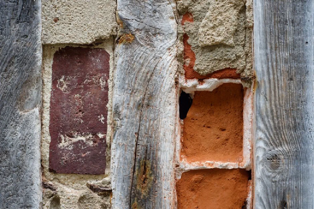 Close-up of rustic mixed materials with aged brick and wood textures.