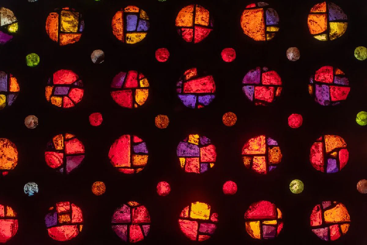 Colorful stained glass circles with geometric patterns on a dark background, creating a vivid artistic display.